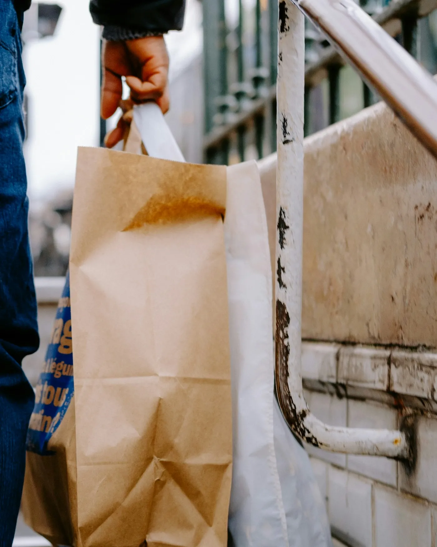 En person bærer en papirpose med takeaway