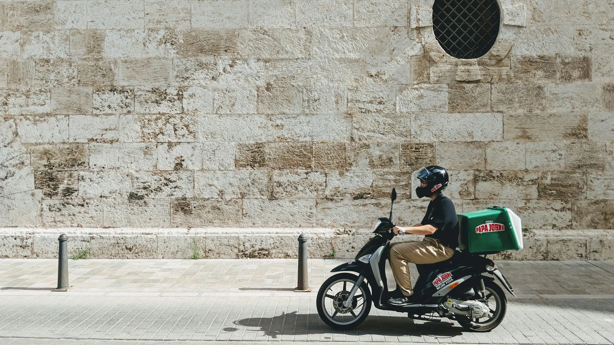 Et bud på scooter i en bygate