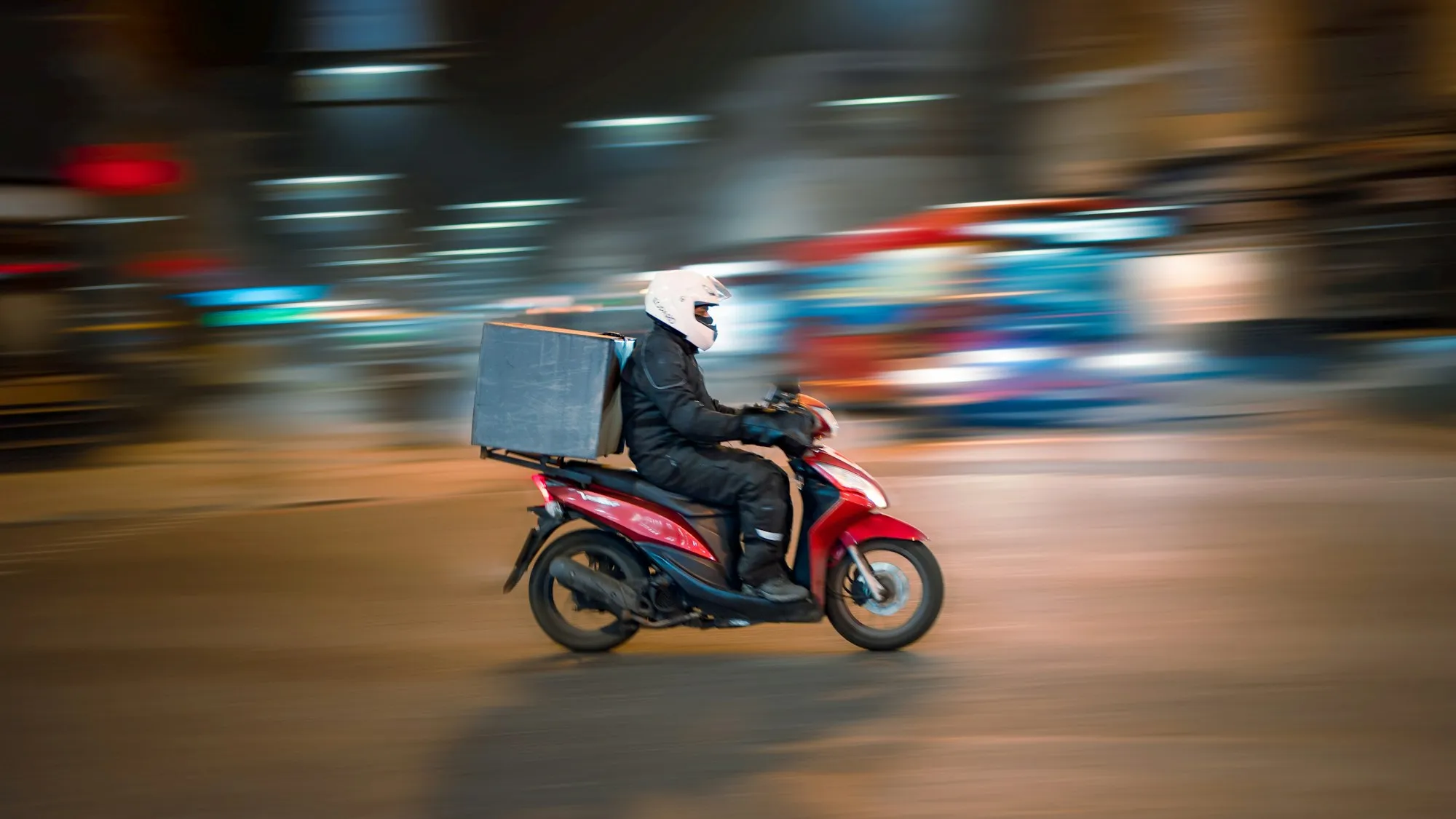 En leveringsscooter i en bygate om kvelden